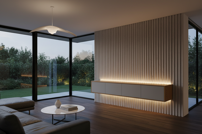 Modern living room interior with a slatted wood accent wall, floating light gray cabinet with warm under-light, dark wood flooring, large floor-to-ceiling windows, and an outdoor garden view.