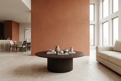 Low-profile espresso round coffee table in a terracotta luxury interior