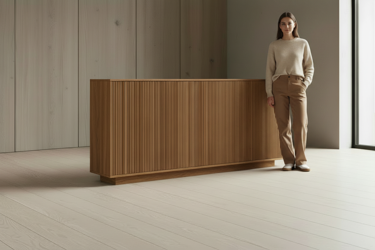 Person standing beside a natural oak sideboard for scale reference