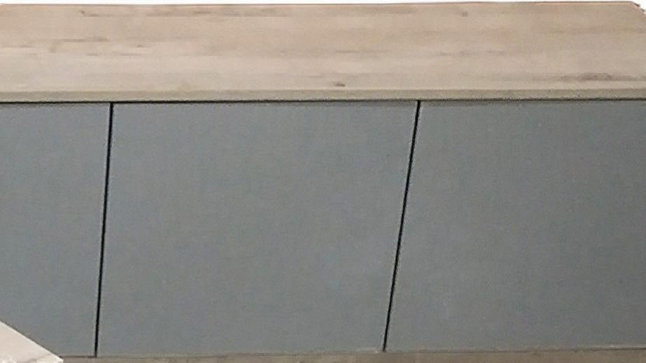 TRENZY Spaces Lux TV stand featuring a light wood grain top and sleek grey cabinet doors in a modern minimalist style.