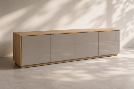 TRENZY Spaces Lux TV stand featuring a light oak wood frame and smooth, glossy taupe cabinet doors in a modern room.